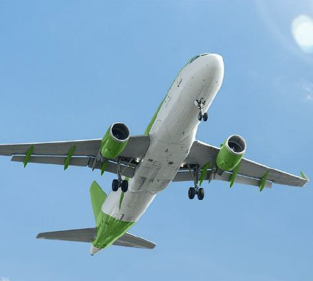 A green and white plane flies overhead