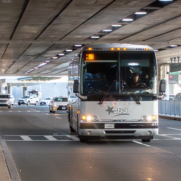 Coach bus pulling up to a curb