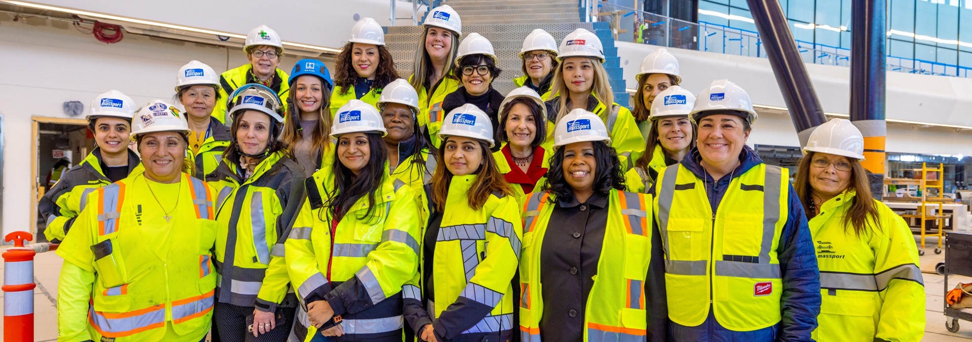 Group of women wearing hi-vis gear and hard hats in a construction site