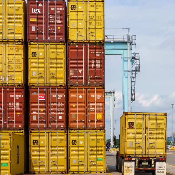 Stacked Shipping containers next to a truck