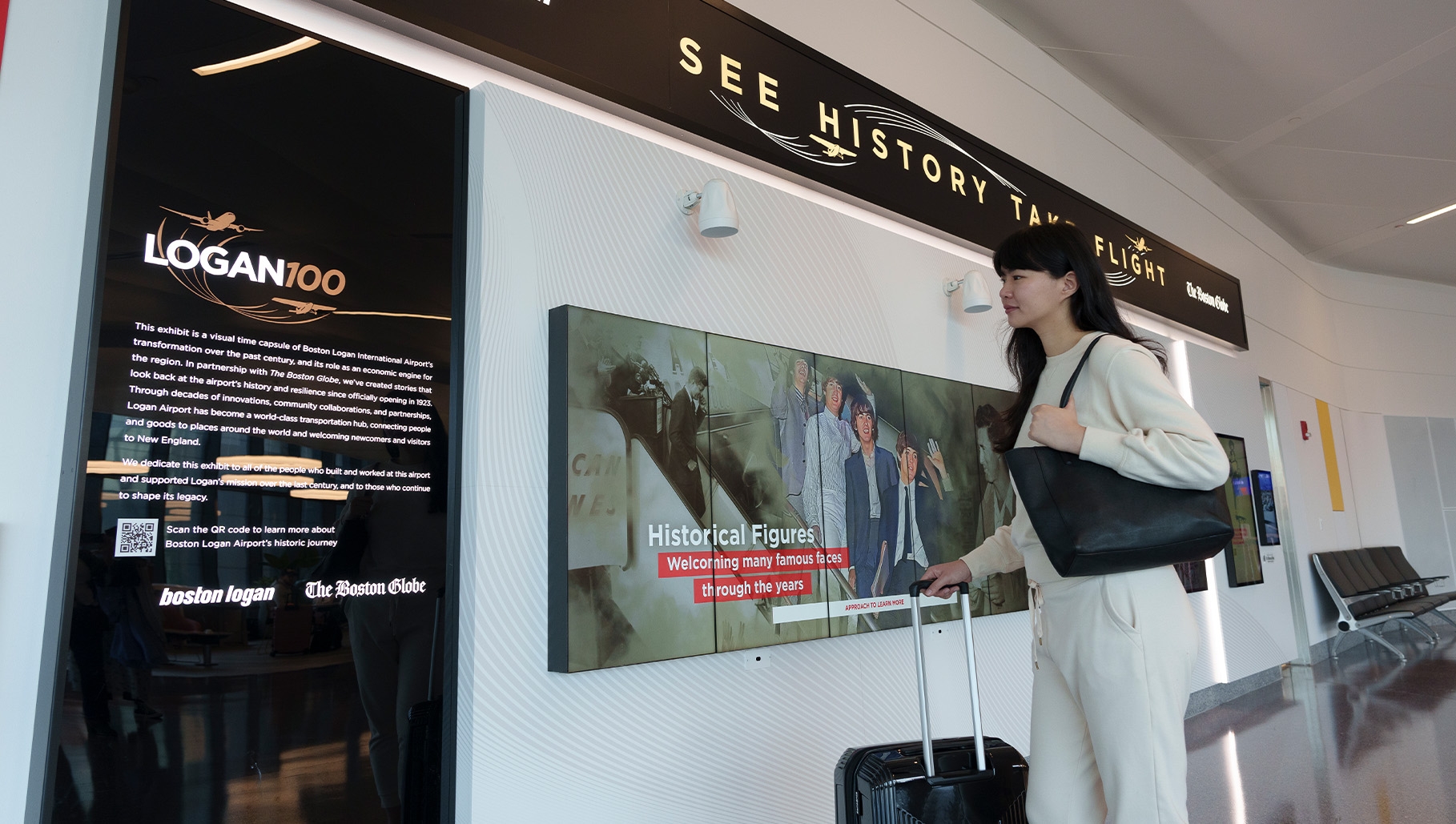 Woman standing in front of Logan 100 exhibit