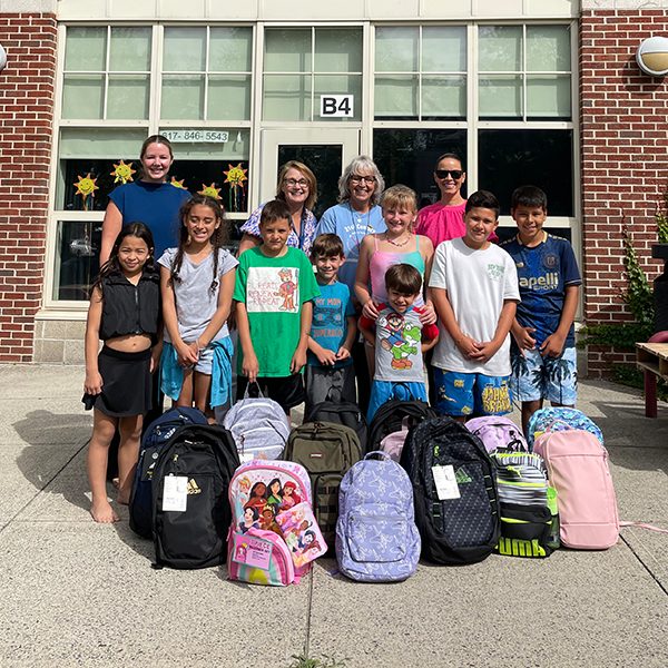 kids with backpacks in front of school